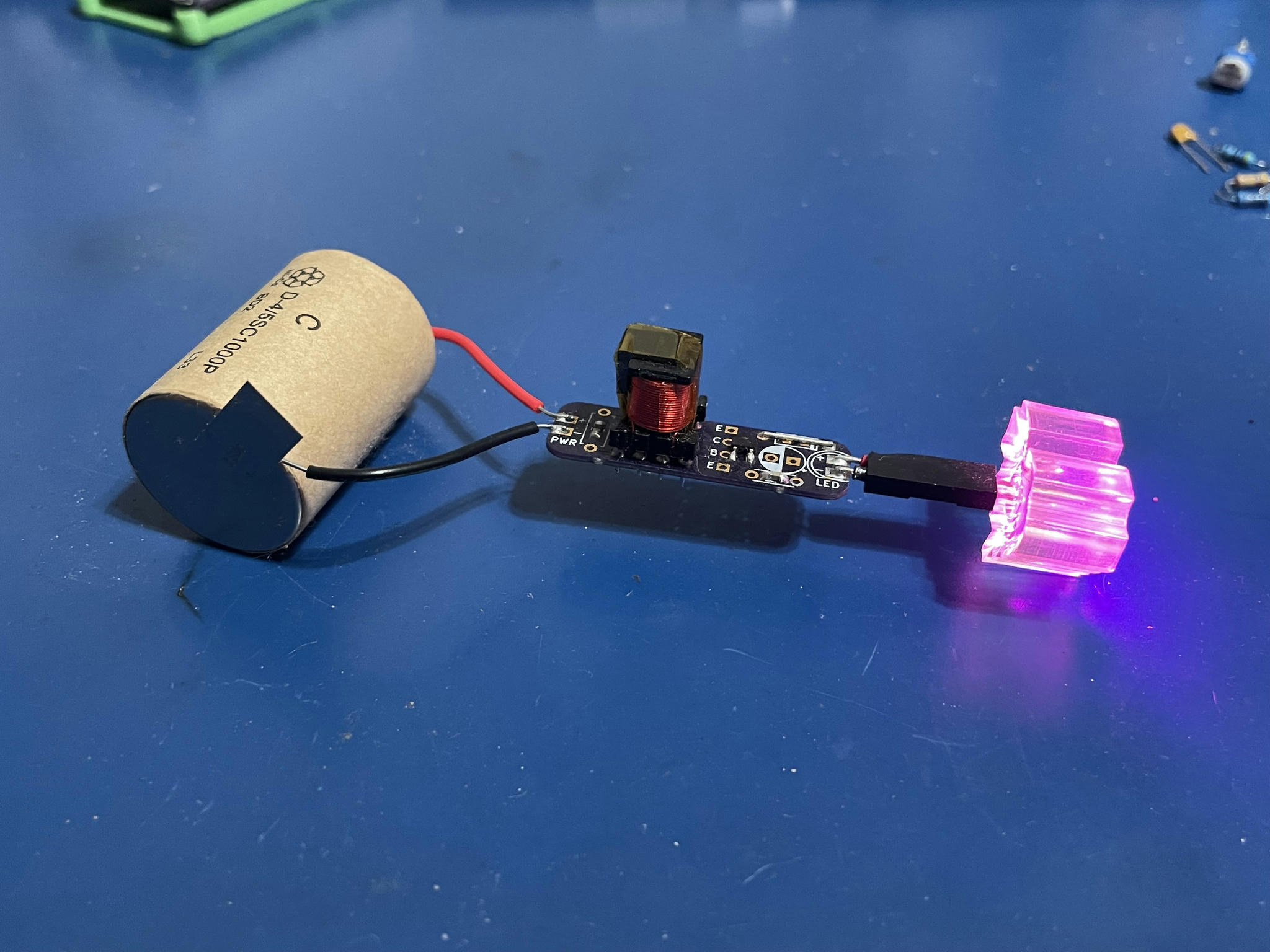 A joule thief using SMD components powering a heart
  shaped pink LED